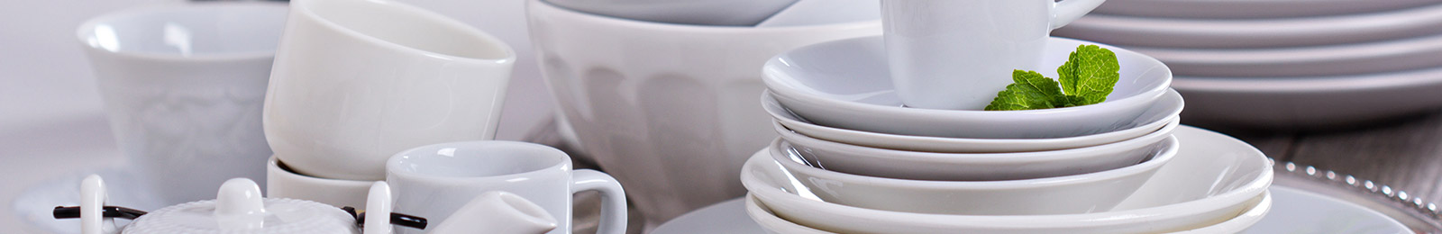 stacks of white dishes, bowls, and mugs