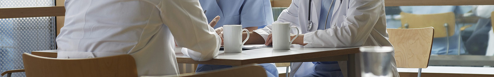 Three medical professionals talking over coffee