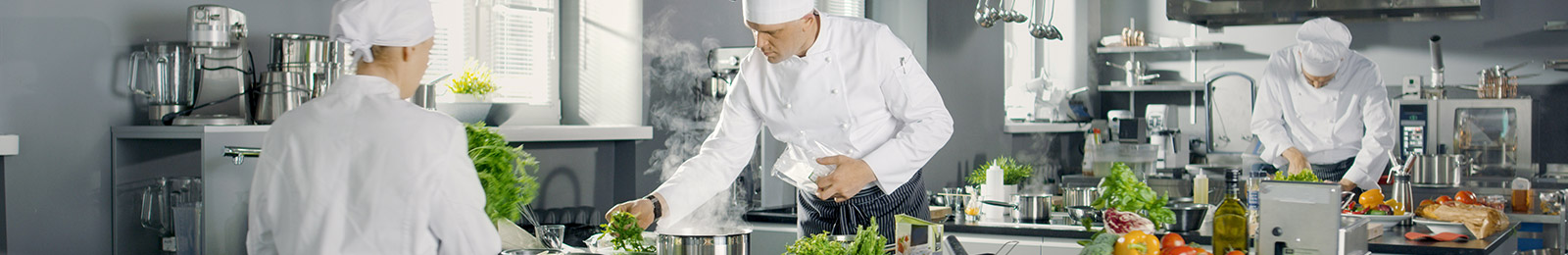 Three chefs working in a professional kitchen